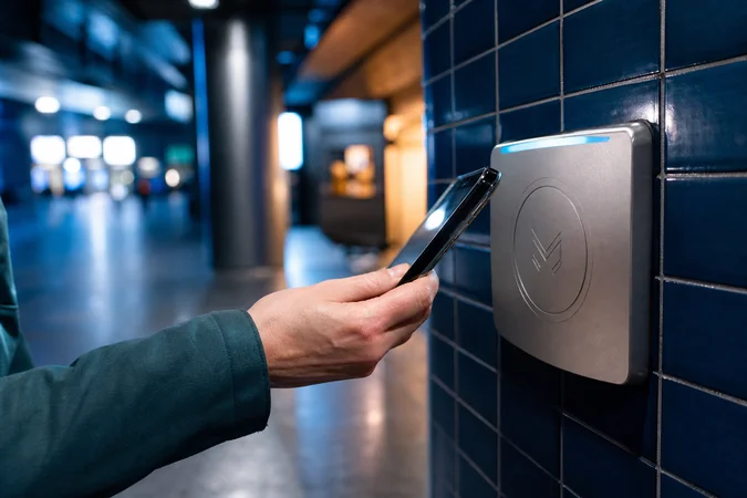 Mano sosteniendo smartphone junto a lector de recarga sin contacto